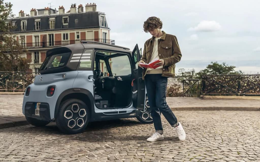 étudiant à Paris à côté de la Citroën Ami