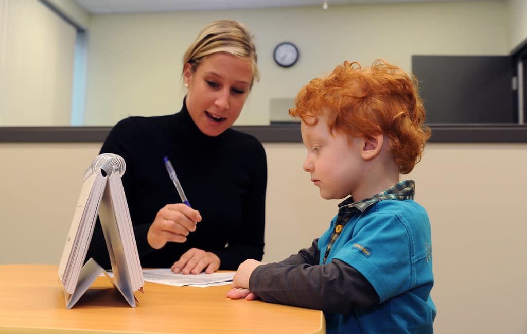 orthophoniste lors d'une séance d'écriture avec un enfant