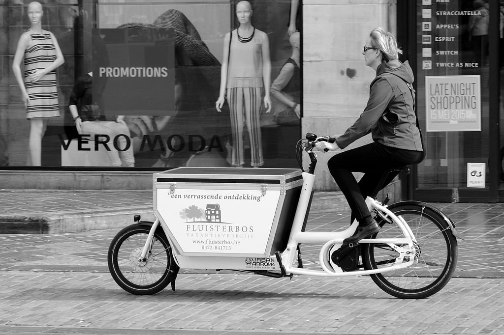 femme qui se déplace avec un vélo cargo de type biporteur