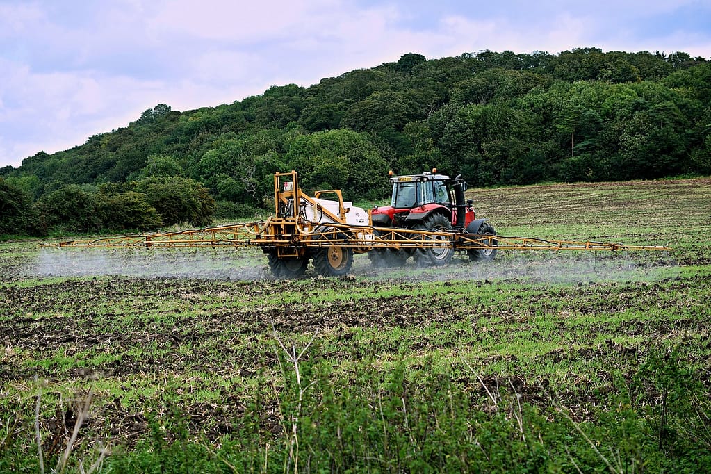 tracteur qui pulvérise un fertilisant dans un champ