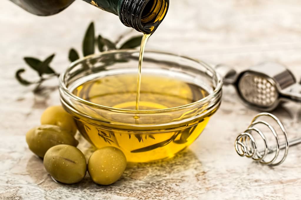 bouteille d'huile d'olive qui se verse dans un petit bol