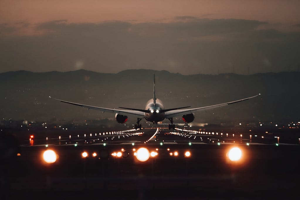 avion qui atterrit de nuit dans un aéroport