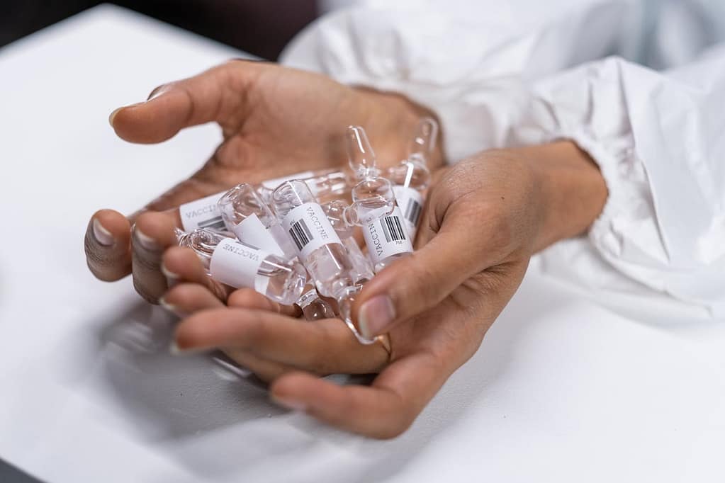 mains qui tiennent des emballages en verre pour le secteur pharmaceutique