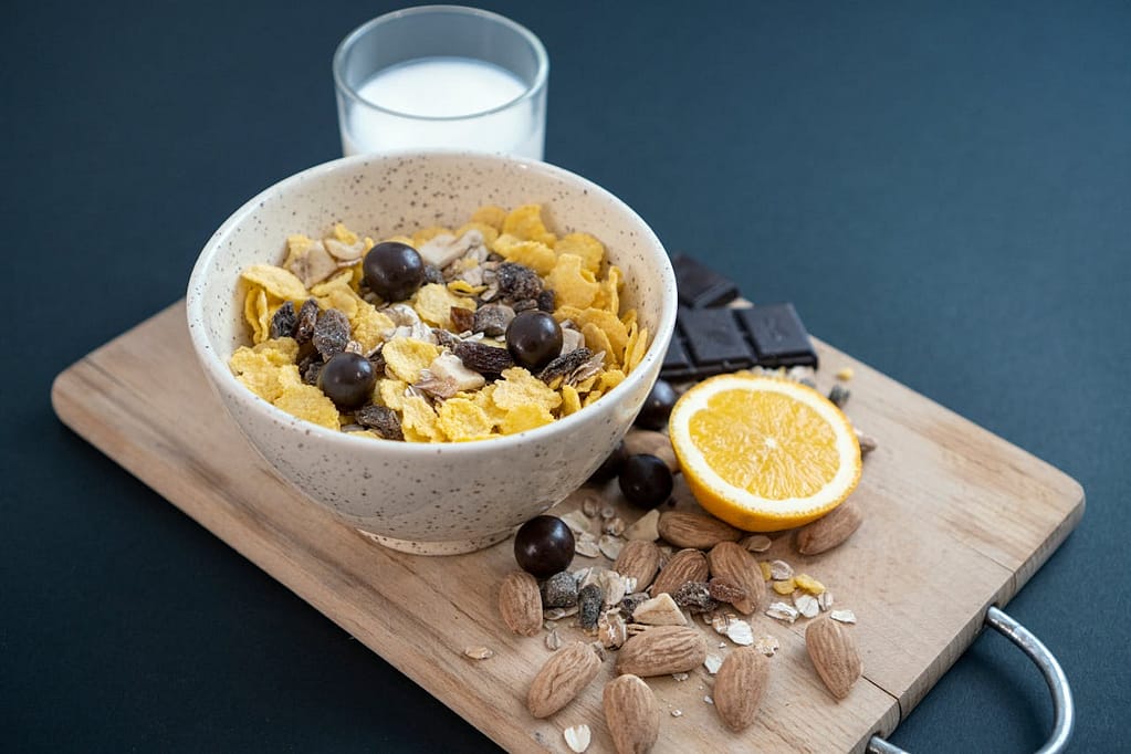 Bol rempli de céréales pour petit déjeuner avec un verre de lait