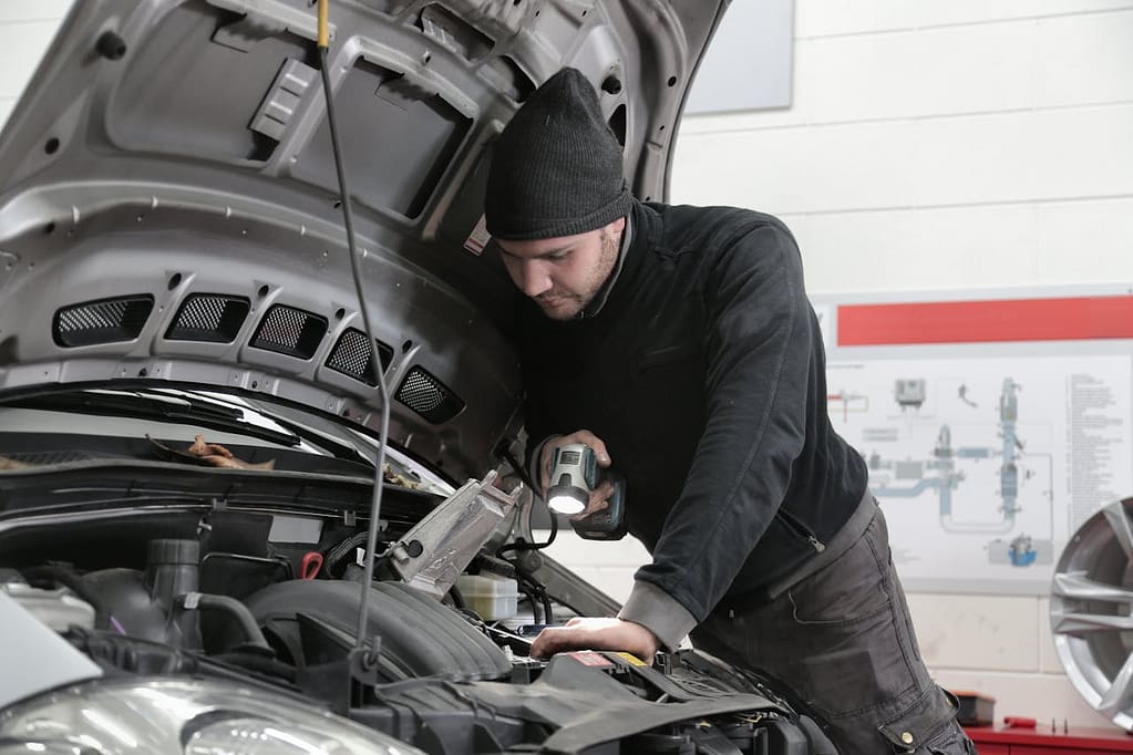 un mécanicien qui examine le capot d'une voiture