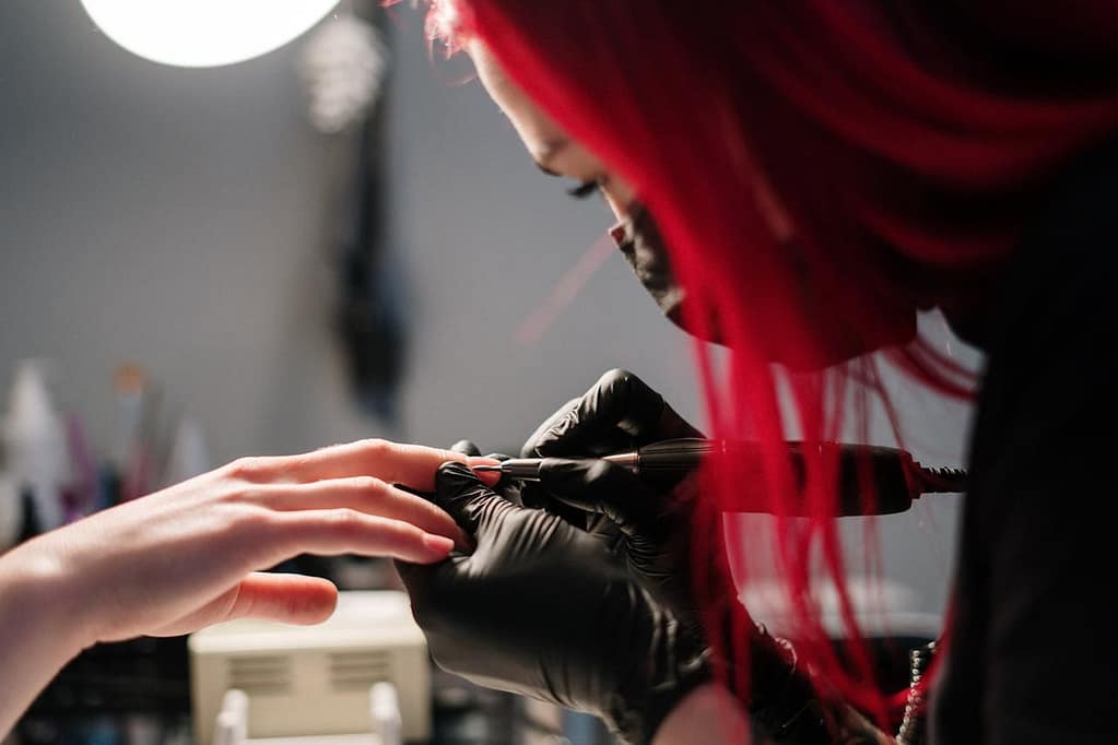 nail artist qui réalise une manucure dans un salon