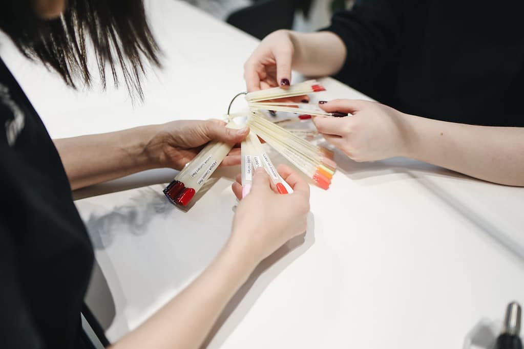 cliente qui choisit la couleur de son vernis à ongles dans un salon