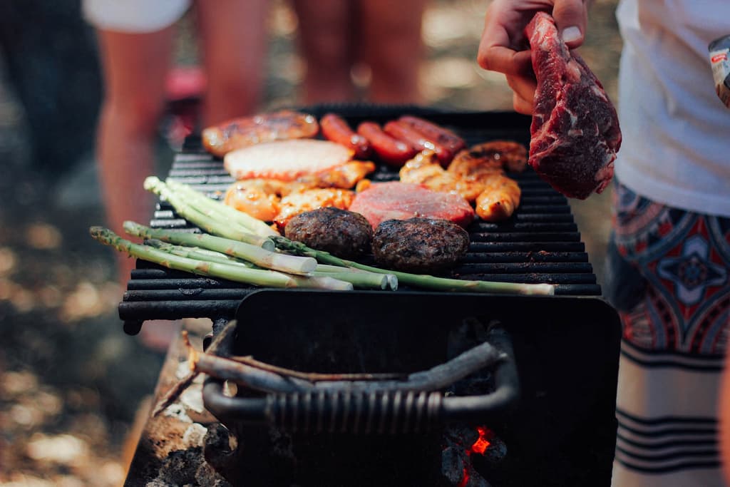 légumes et plusieurs sortes de viande qui grillent sur un barbecue