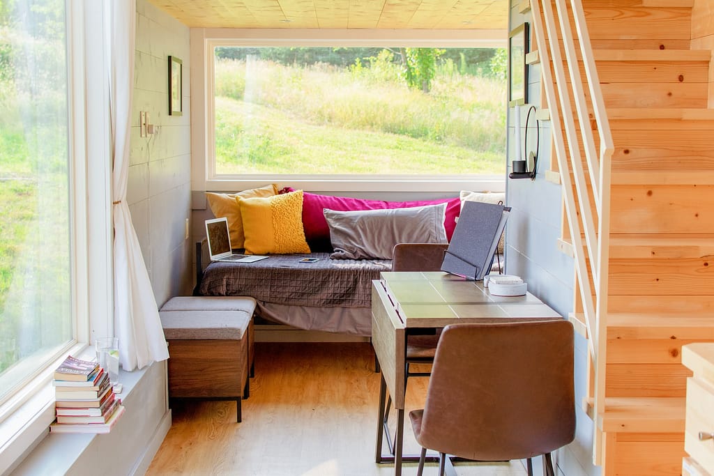 intérieur d'une tiny house en bois lumineuse avec vue sur l'extérieur