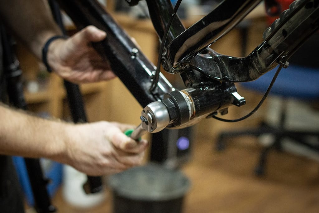 un homme qui répare un vélo dans son atelier de réparation