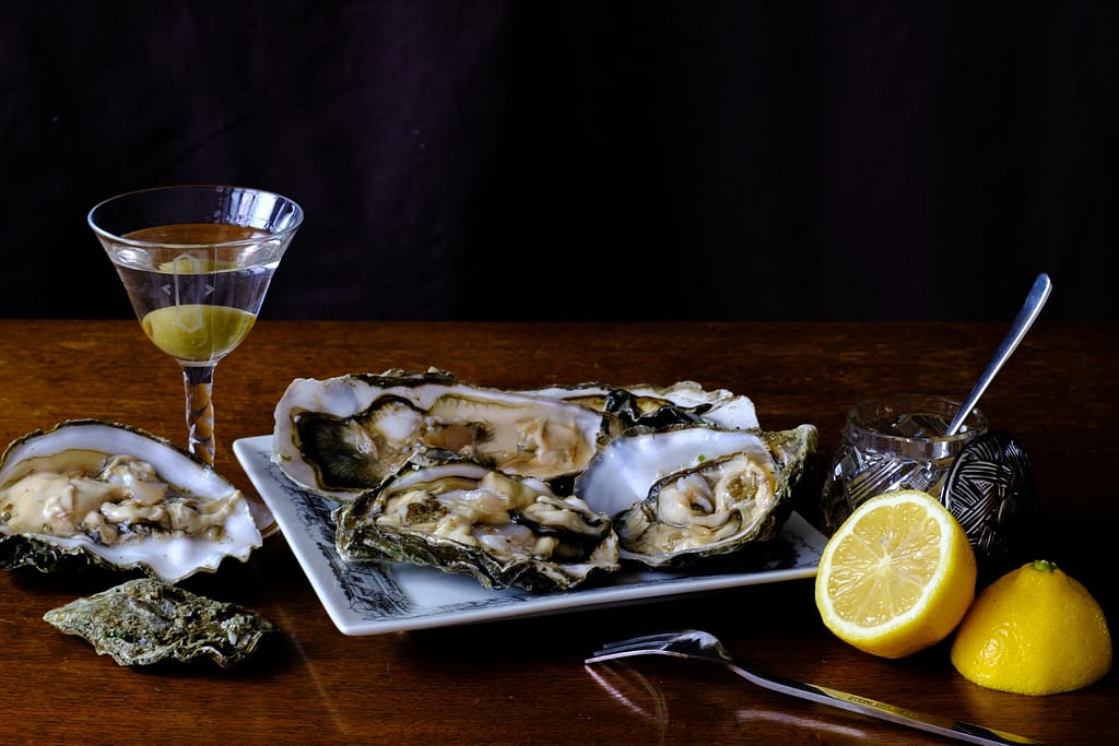 plusieurs huitres accompagnées d'un citron et d'une boisson