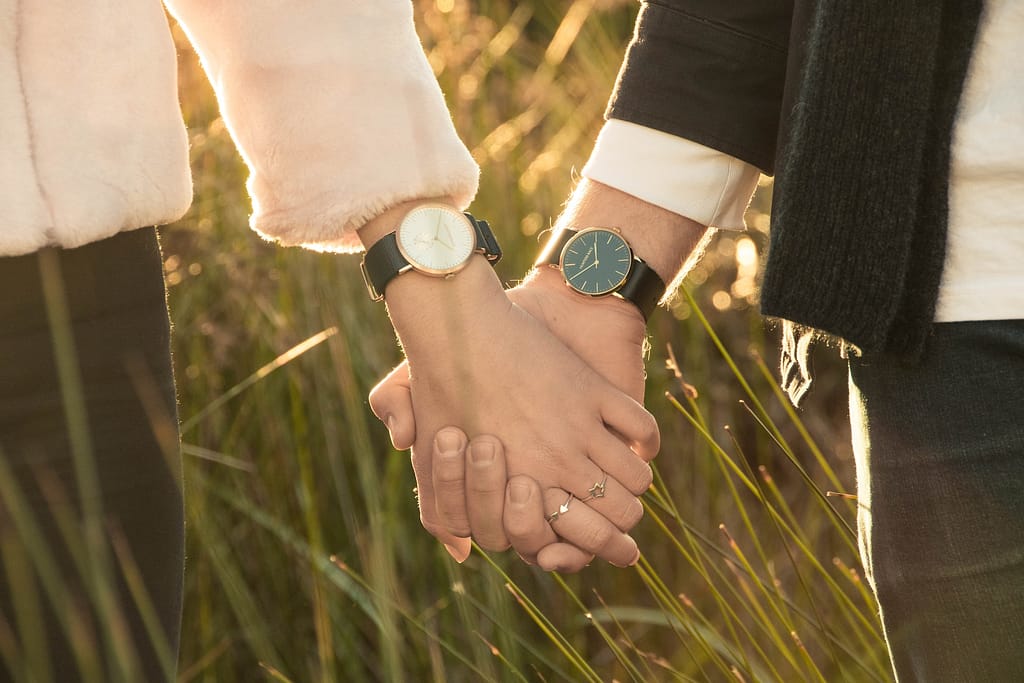 un homme et une femme qui se tiennent la main avec chacun une montre au poignet