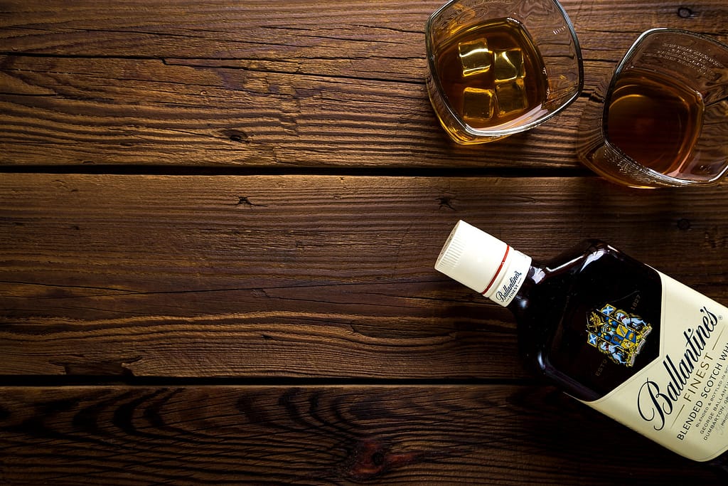 deux verres de whisky sur une table avec une bouteille