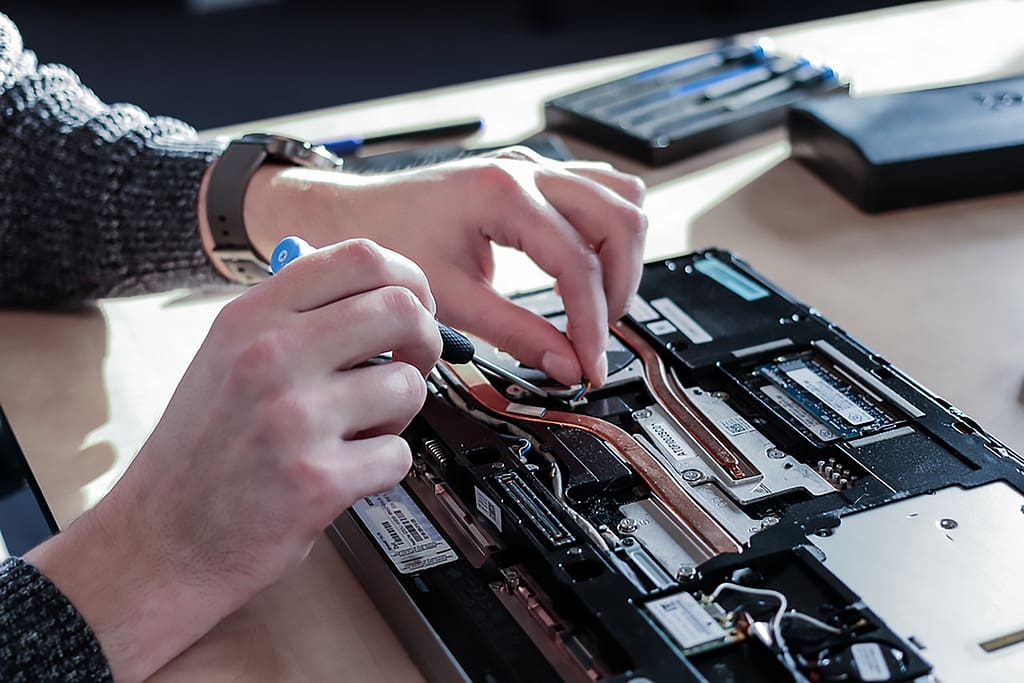 technicien qui répare un ordinateur portable