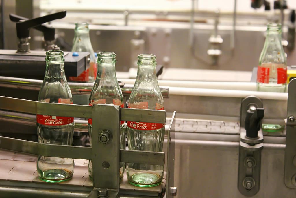 chaîne d'embouteillage avec des bouteilles coca cola vides en verre