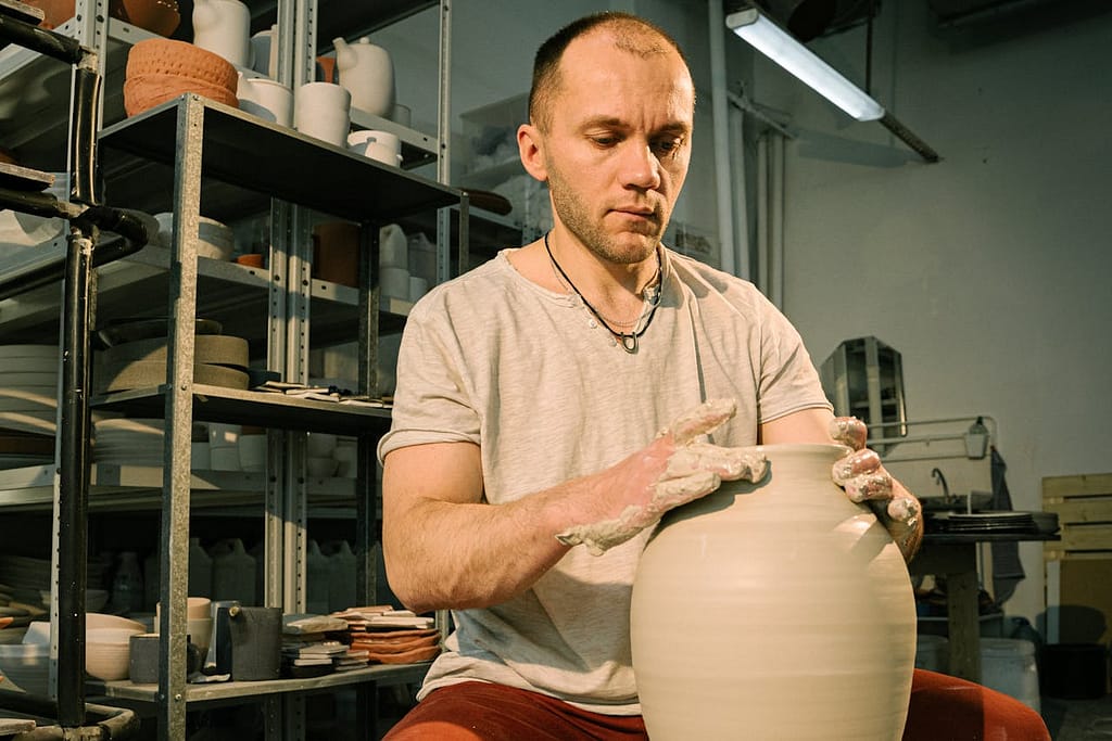 un homme qui fait un vase en céramique