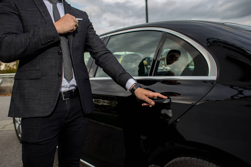 chauffeur qui ouvre la porte à un client