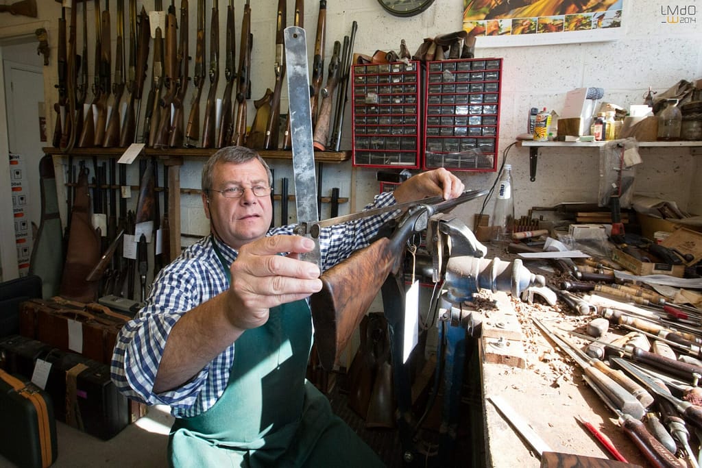 armurier qui répare un fusil de chasse