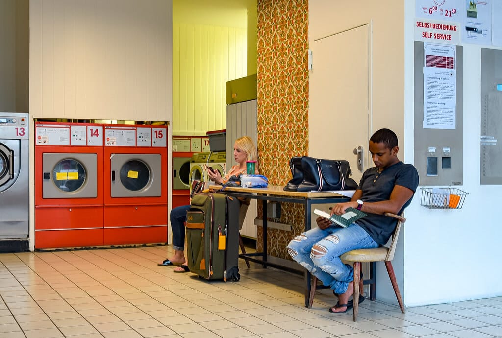 deux personnes patientent dans une laverie automatique