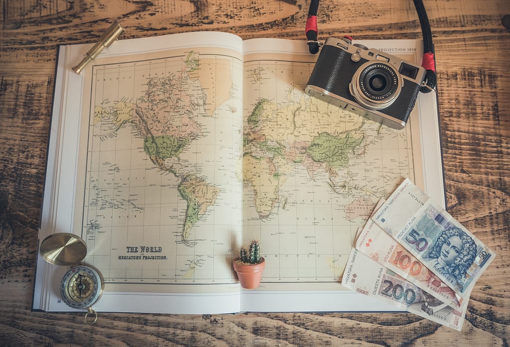 carte du monde, boussole et appareil photo qui symbolisent le voyage personnalisé