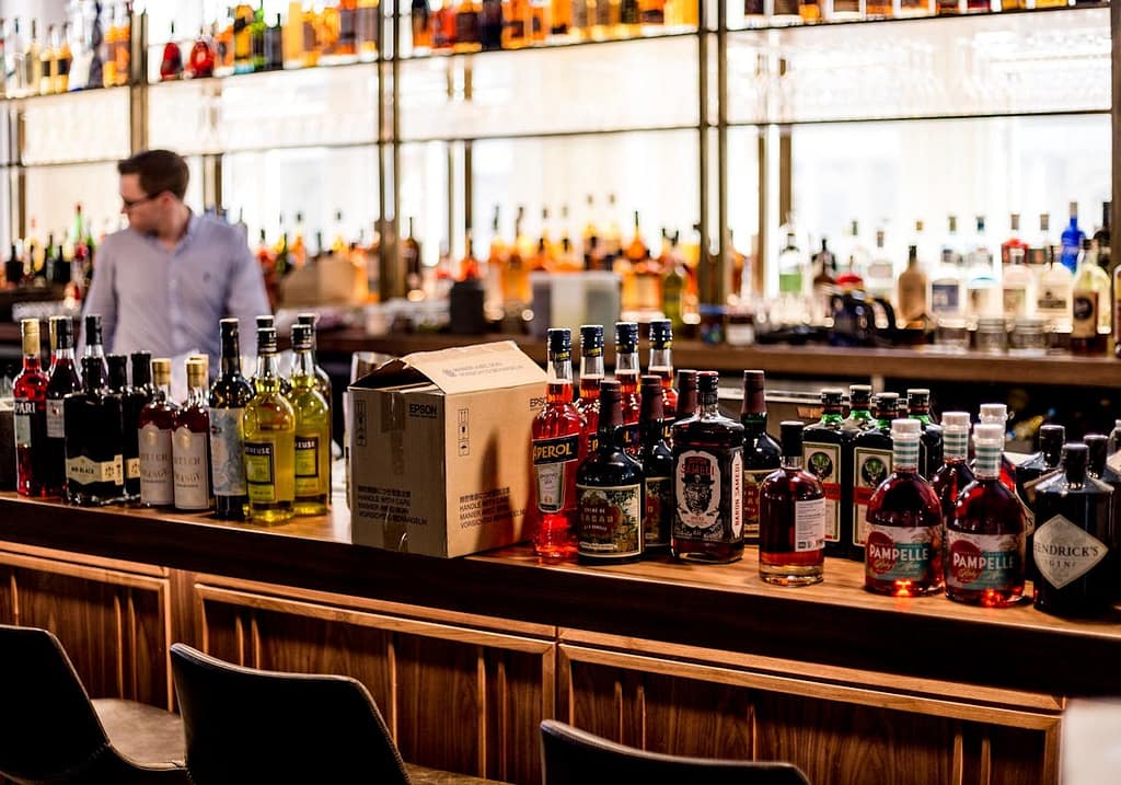comptoir d'un bar avec plusieurs bouteilles de spiritueux