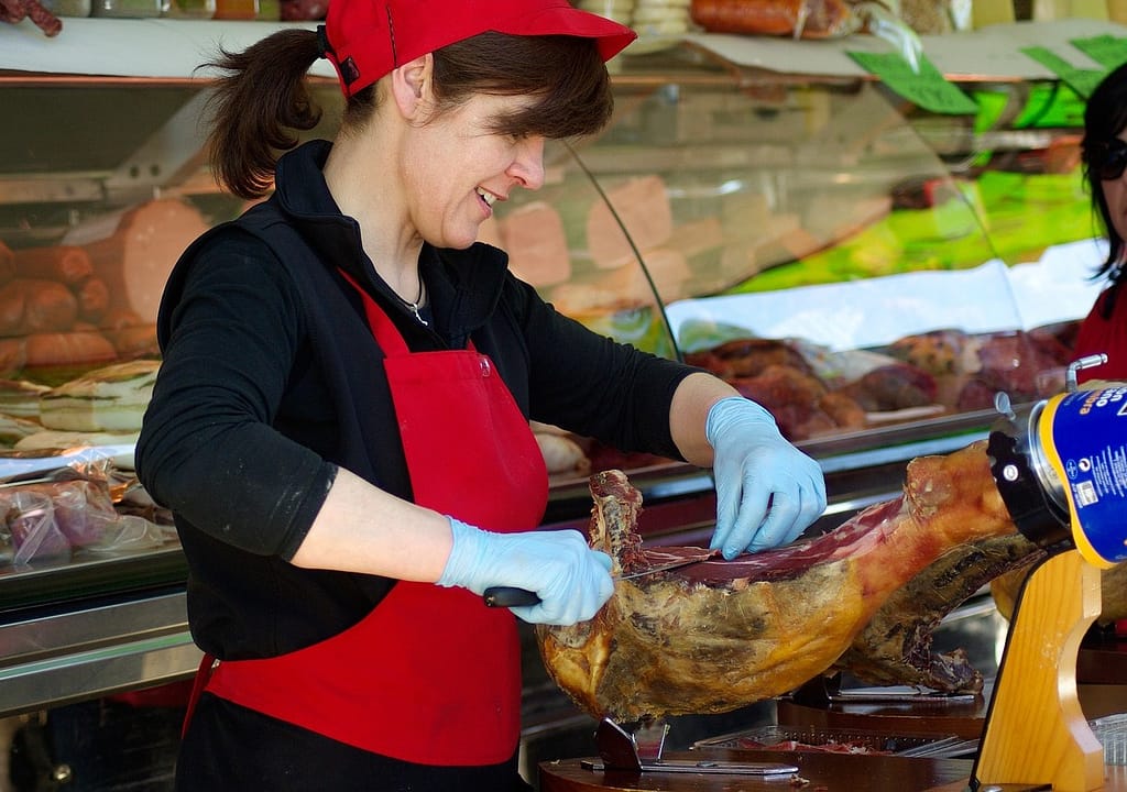 boucher qui coupe de la viande dans son atelier