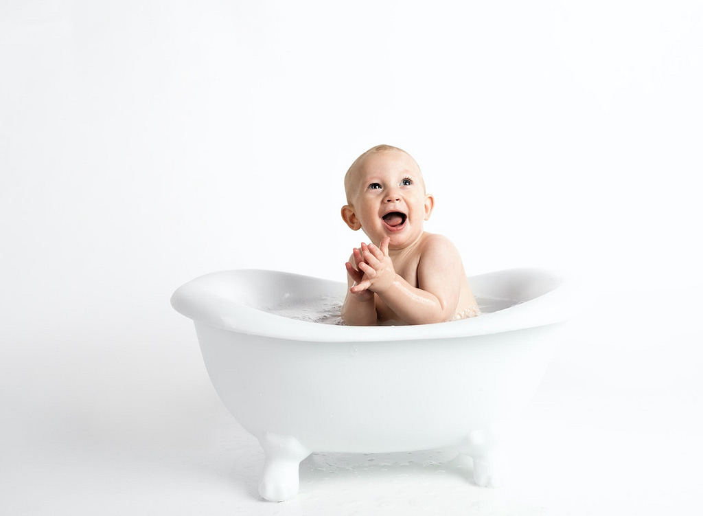 bébé qui fait sa toilette dans un bain