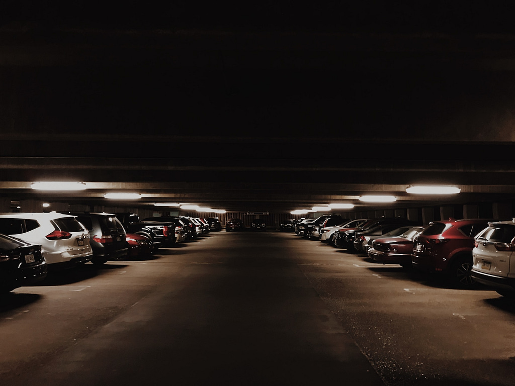 Étage d'un parking souterrain la nuit avec peu de lumière