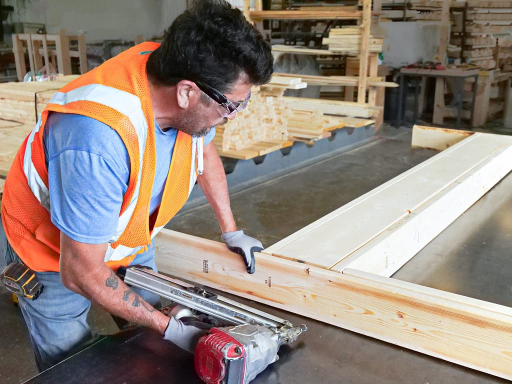 ouvrier travaillant sur une poutre en bois