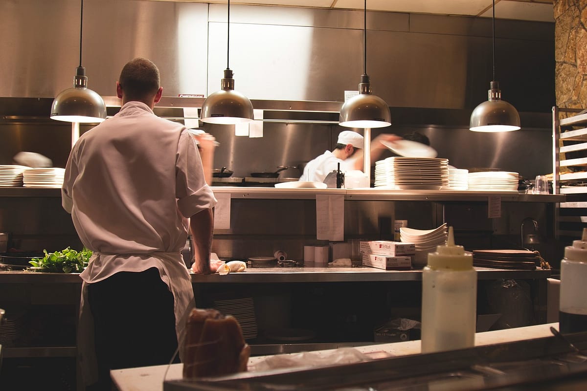 cuisiniers qui préparent des plats dans une dark kitchen