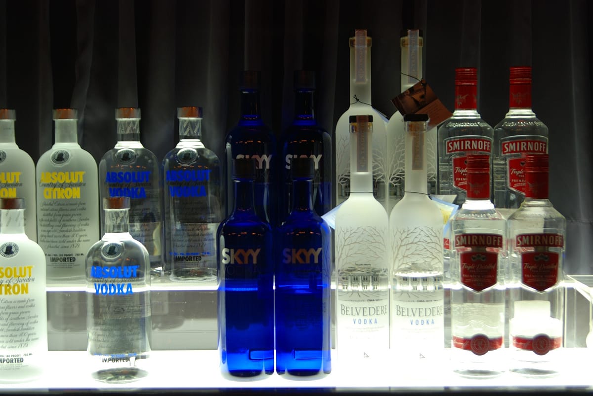 plusieurs bouteilles de différentes marques de vodka sur un comptoir de bar