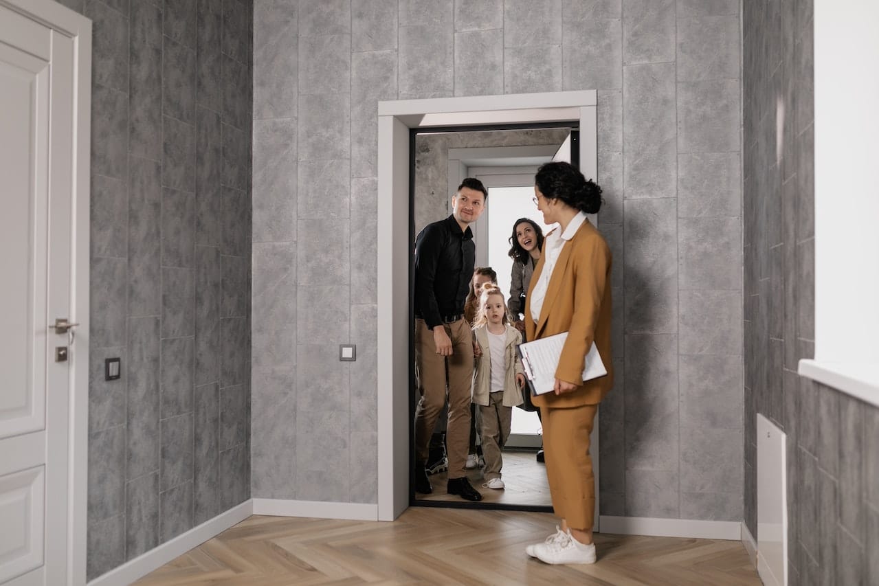 agent mandataire qui fait visiter le salon à une famille
