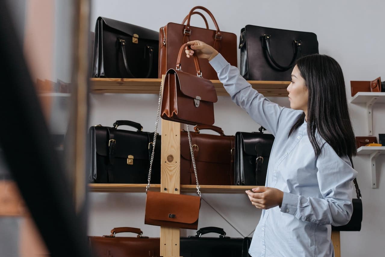 femme dans une boutique qui choisit un sac à main