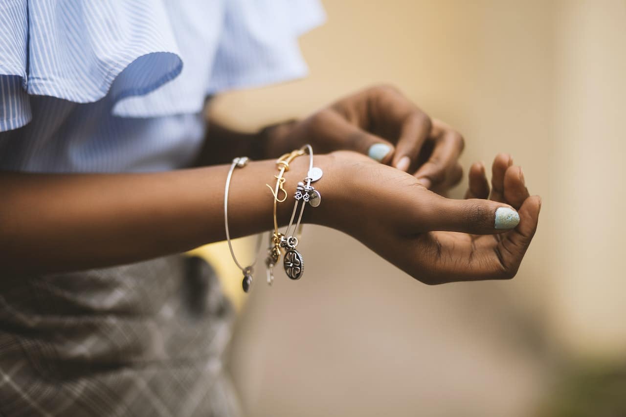 femme qui porte au poignet plusieurs bracelets fantaisie