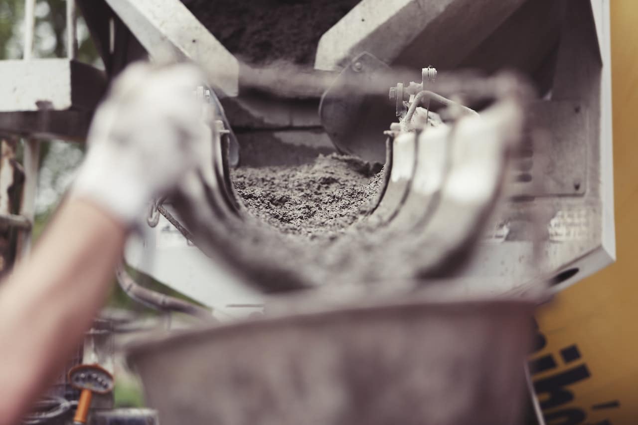 canaux de ciment qui se déverse dans un récipient sur un chantier