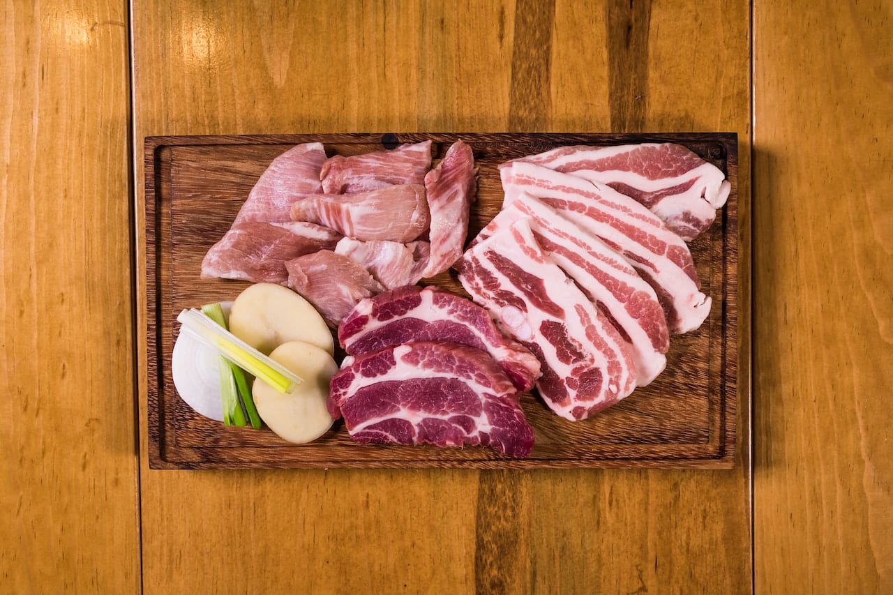 plusieurs types de viande sur un plateau de bois