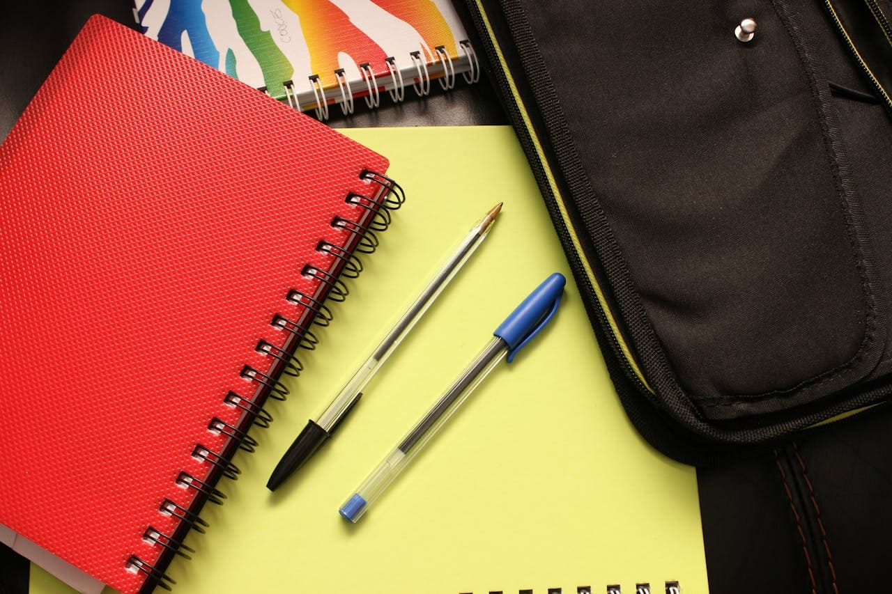 stylos et cahiers de différentes couleurs