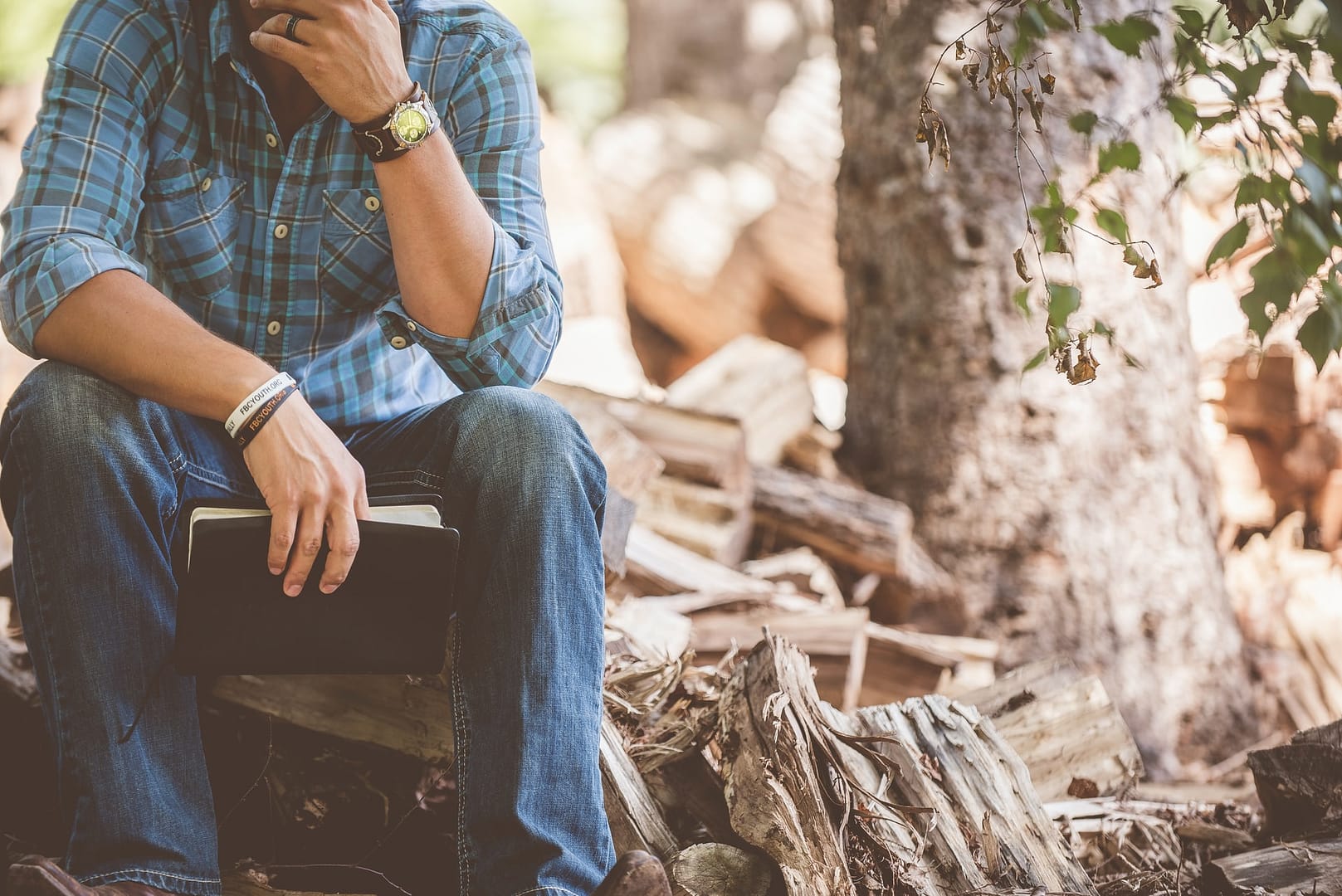 Homme assis sur un banc qui porte une montre et des bracelets
