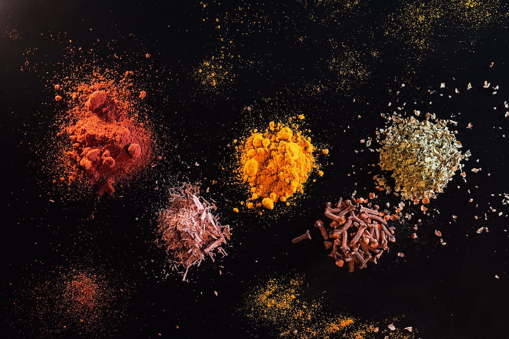 plusieurs tas d'épices sur fond noir