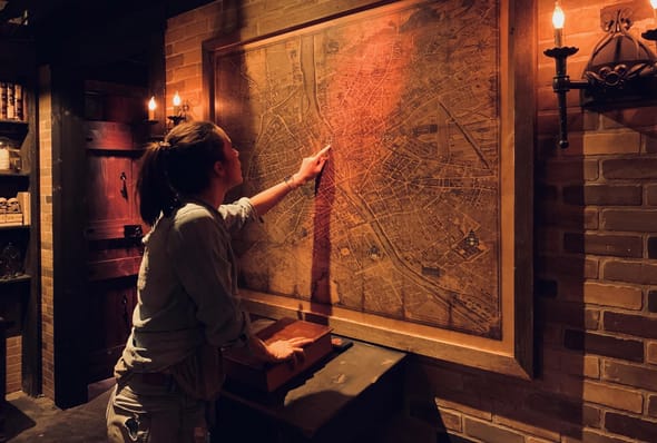 femme qui pose la main sur une carte de Paris dans un escape game