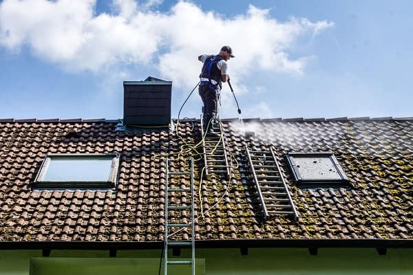 un couvreur qui nettoie une toiture