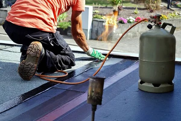 ouvrier qui travaille sur l'étanchéité d'une terrasse