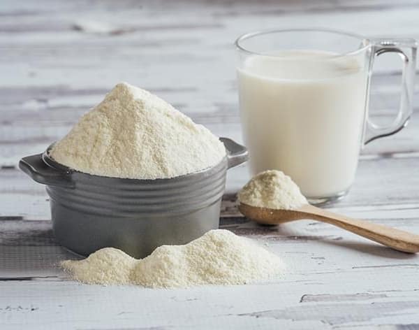 lait en poudre à côté d'un verre de lait