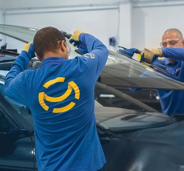 deux opérateurs qui réparent un pare-brise