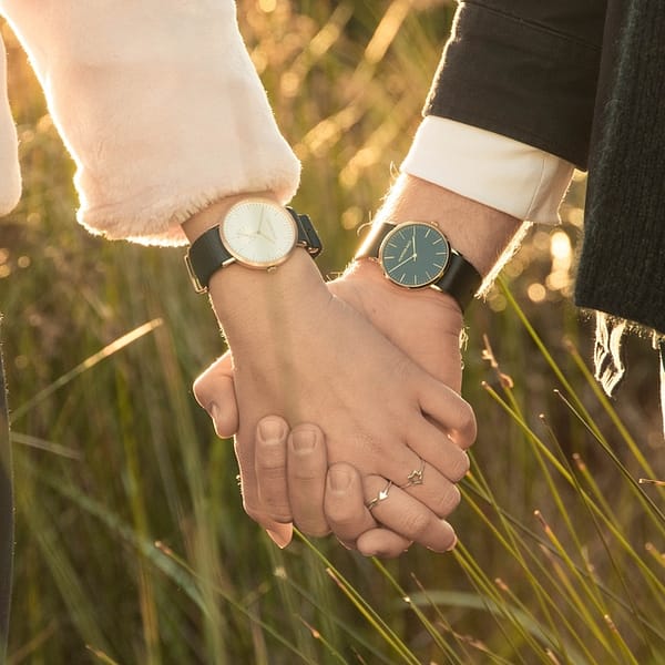 un homme et une femme qui se tiennent la main avec chacun une montre au poignet