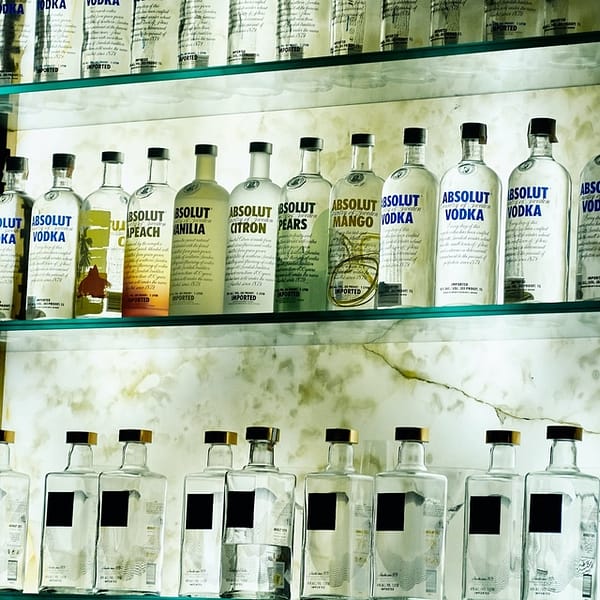 Rangées de bouteilles de vodka de différentes marques dans un bar