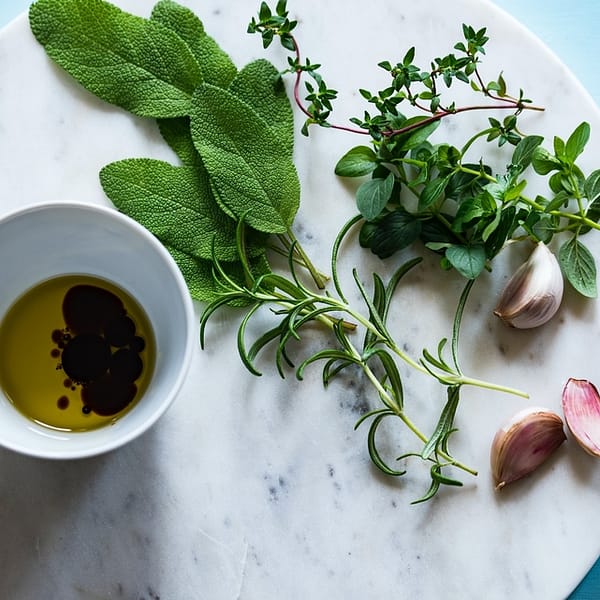 pot de vinaigre balsamique avec des condiments sur un plateau en marbre