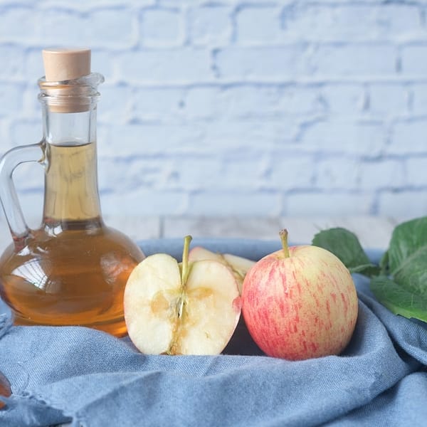 bouteille de cidre à côté d'une pomme