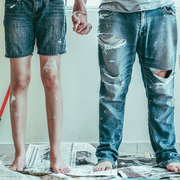 couple en train de peindre une pièce de leur appartement