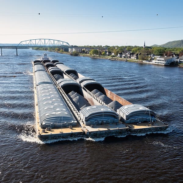 pousseur qui déplace des barges remplies de minerais sur un fleuve